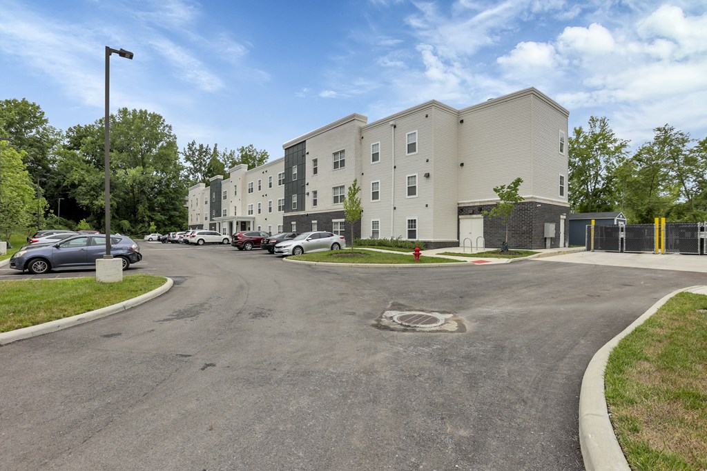 a large apartment building with cars parked in front of it