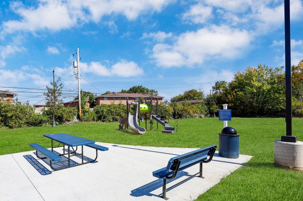 a playground with benches and a picnic table in a park
