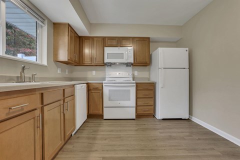 A kitchen with wooden cabinets and white appliances.