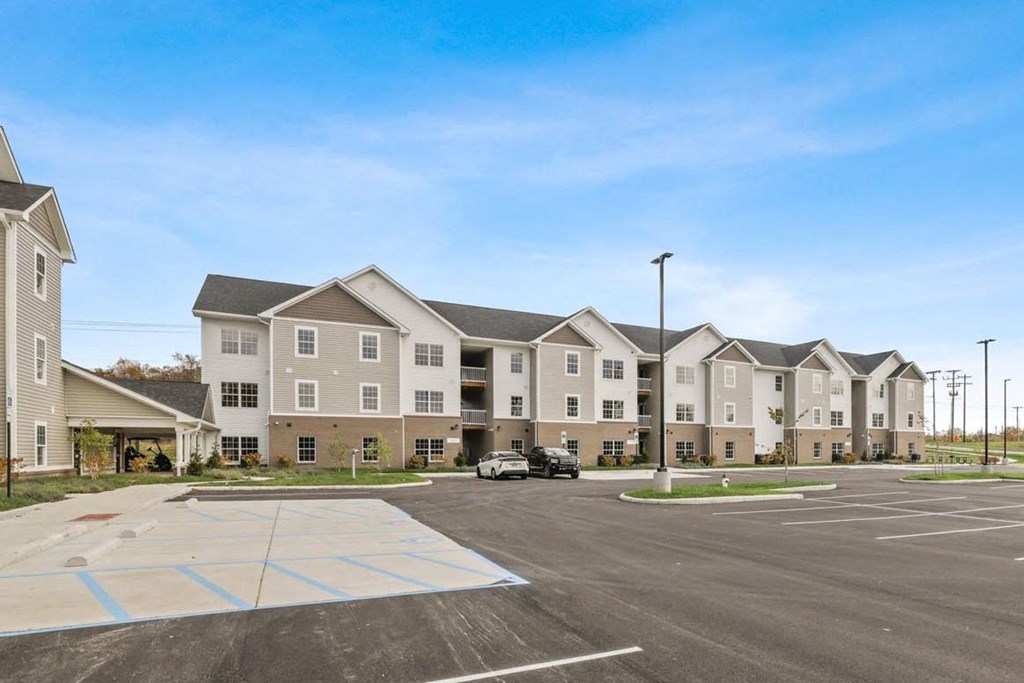 an empty parking lot in front of an apartment building