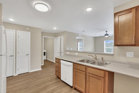 A kitchen with white countertops and wooden cabinets.