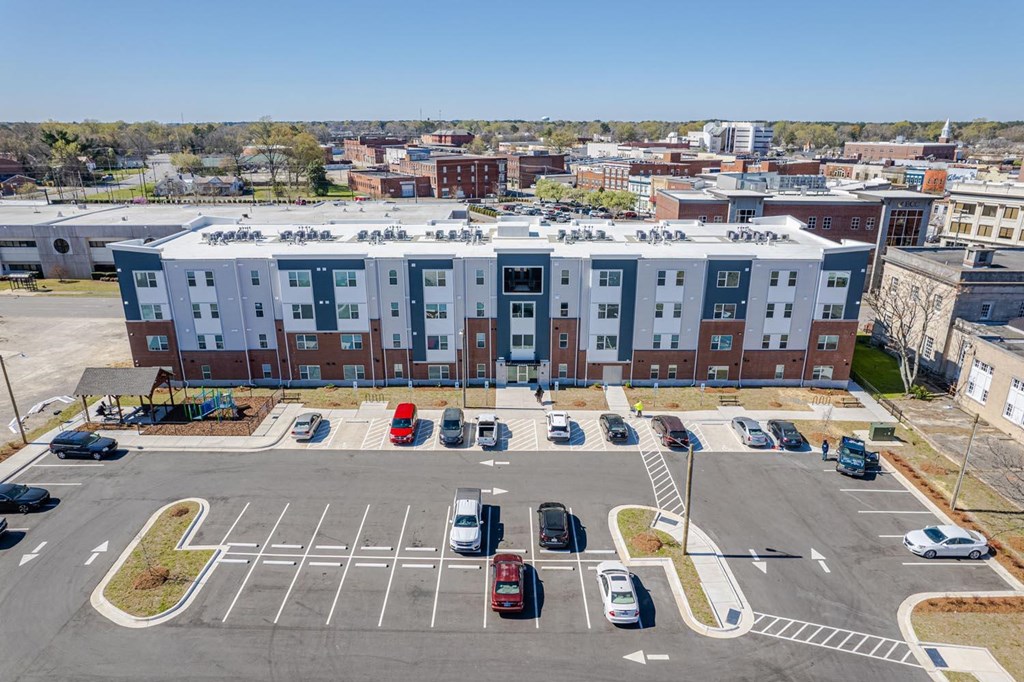 an aerial view of an apartment building in a parking lot