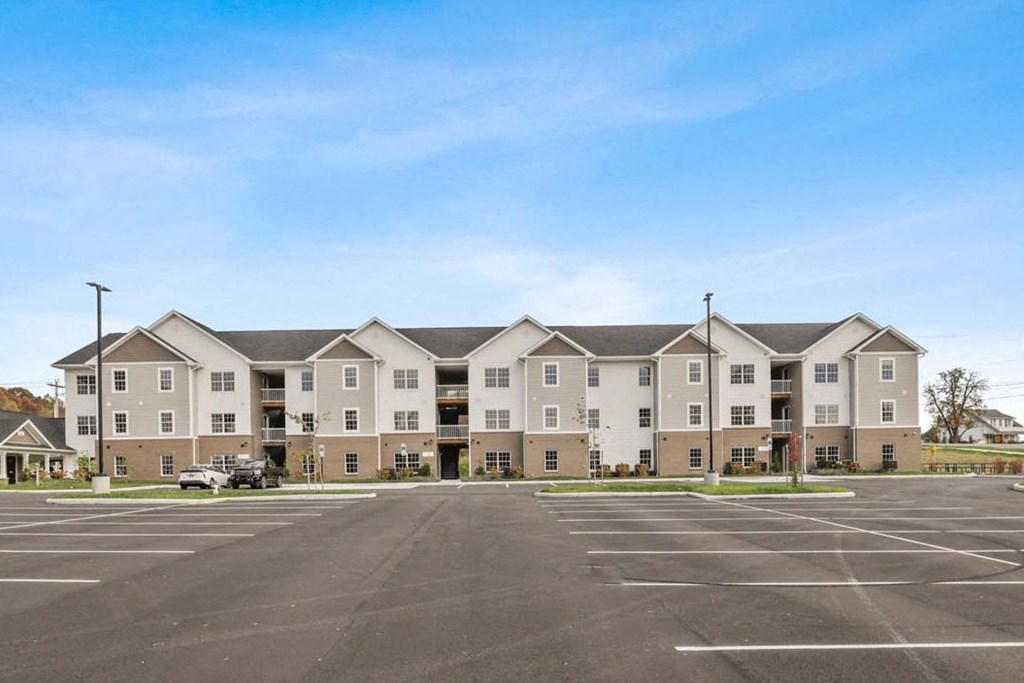 an empty parking lot in front of an apartment building