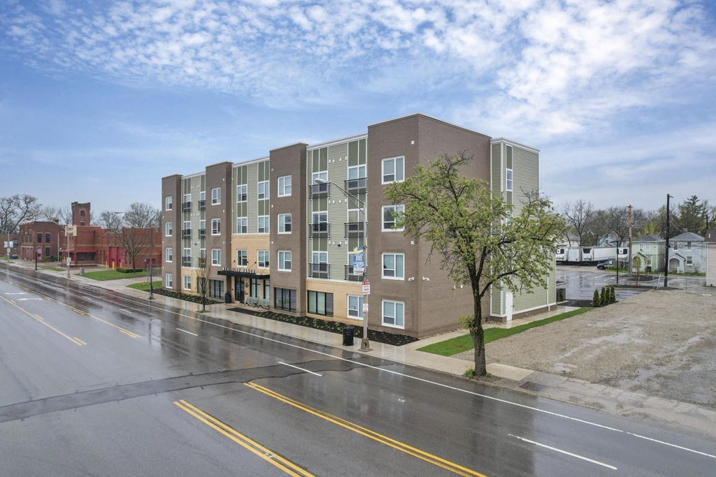 a building with a street in front of it on a rainy day
