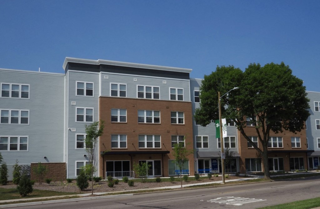 a row of three story apartment buildings on the side of a street