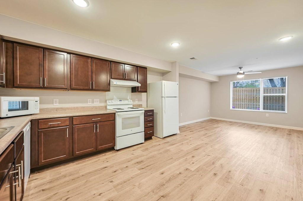 A kitchen with brown cabinets and white appliances.