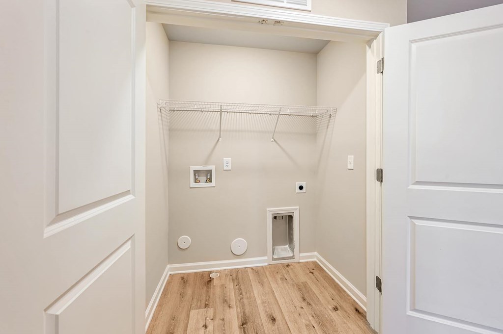A white closet with a door on the right and a shelf on the left.