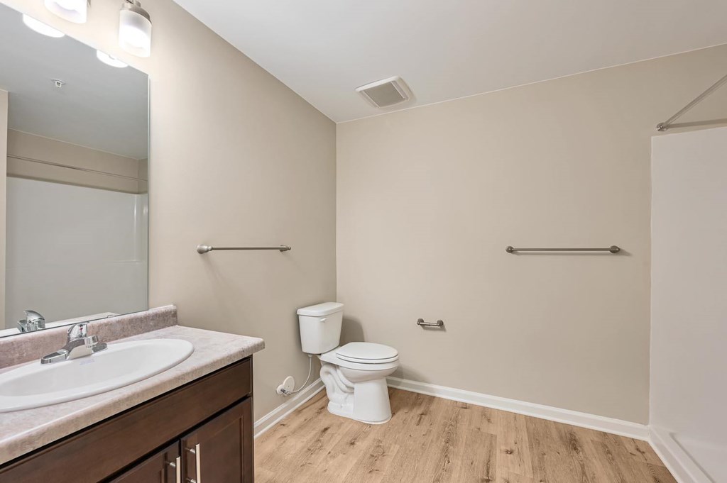 A bathroom with a toilet, sink, and a mirror.