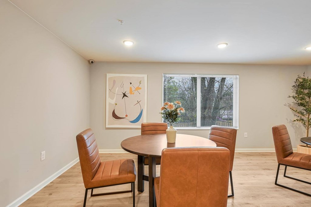 A dining room with a round table and chairs.