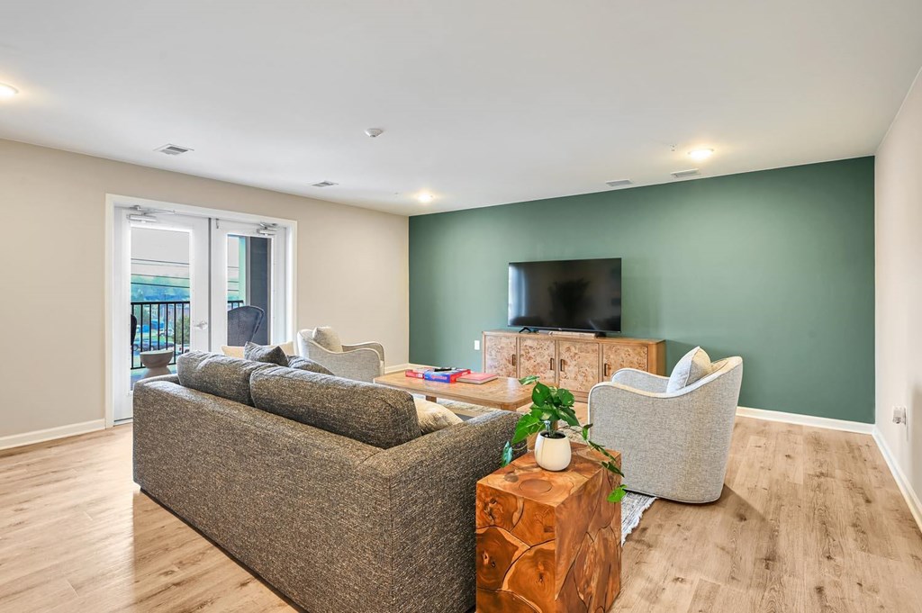A living room with a grey couch, a wooden coffee table, and a flat screen TV.