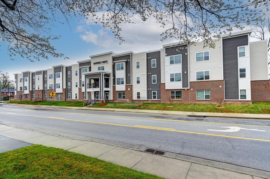 Apartment building with a yellow line on the street in front.