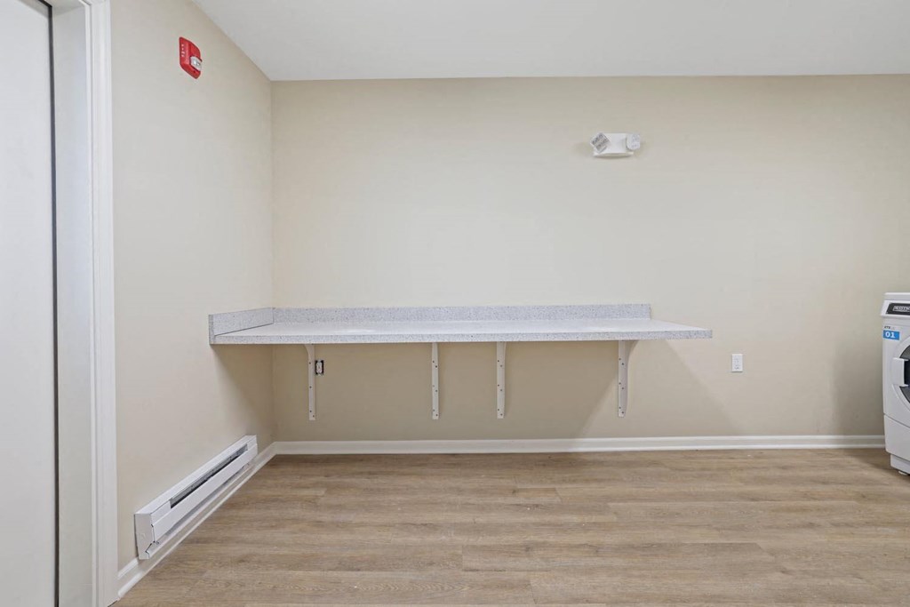 an empty room with a counter and a refrigerator