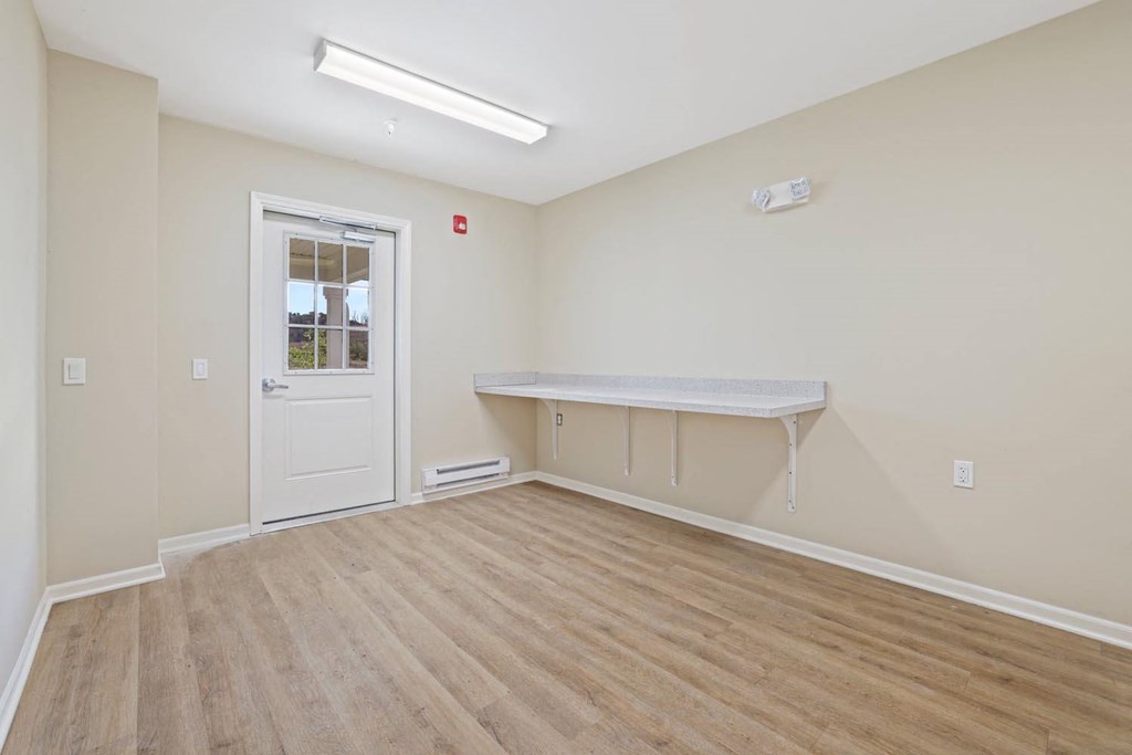 an empty room with a white door and a counter