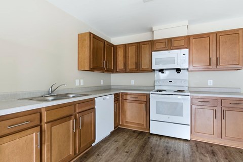 A kitchen with wooden cabinets and white appliances.