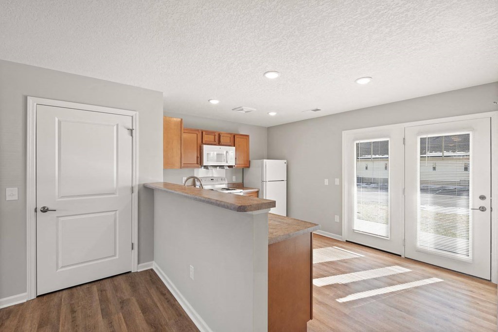 A kitchen with a white door and a white fridge.
