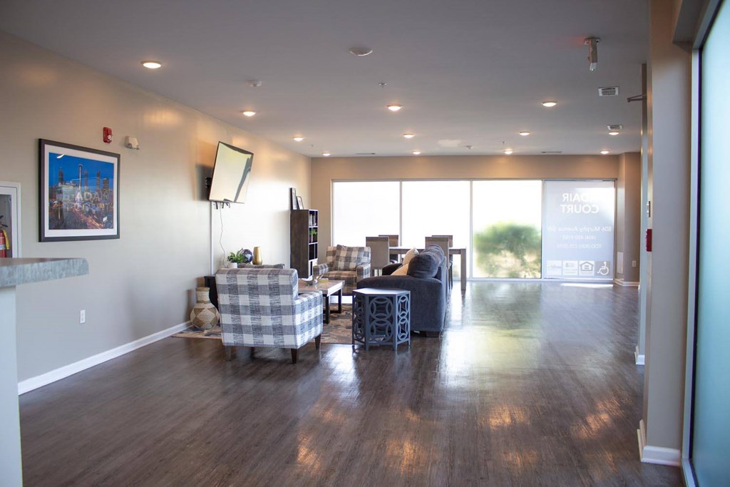 A living room with a checkered couch and a wooden floor.