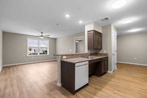 A kitchen with a white dishwasher and wooden cabinets.