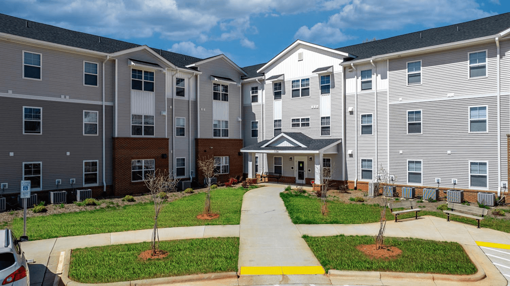 an apartment building with a sidewalk in front of it