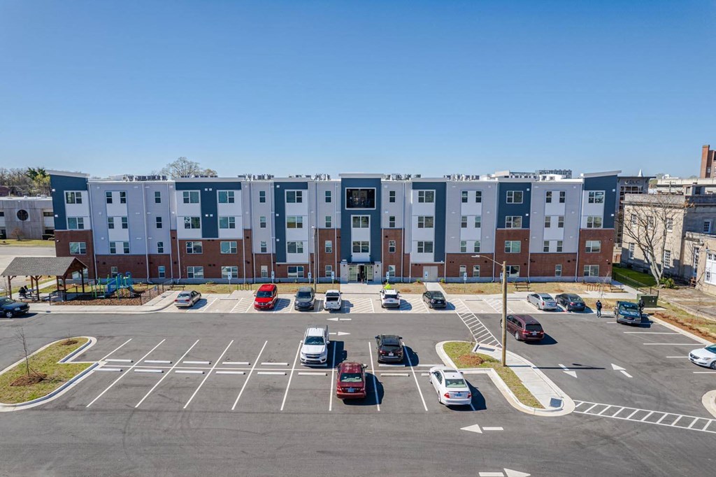 an aerial view of an empty parking lot in front of an apartment building