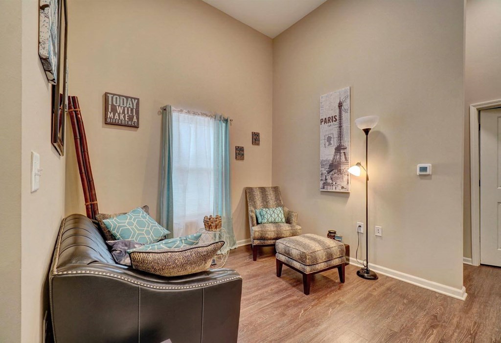 a living room with a leather couch and two chairs