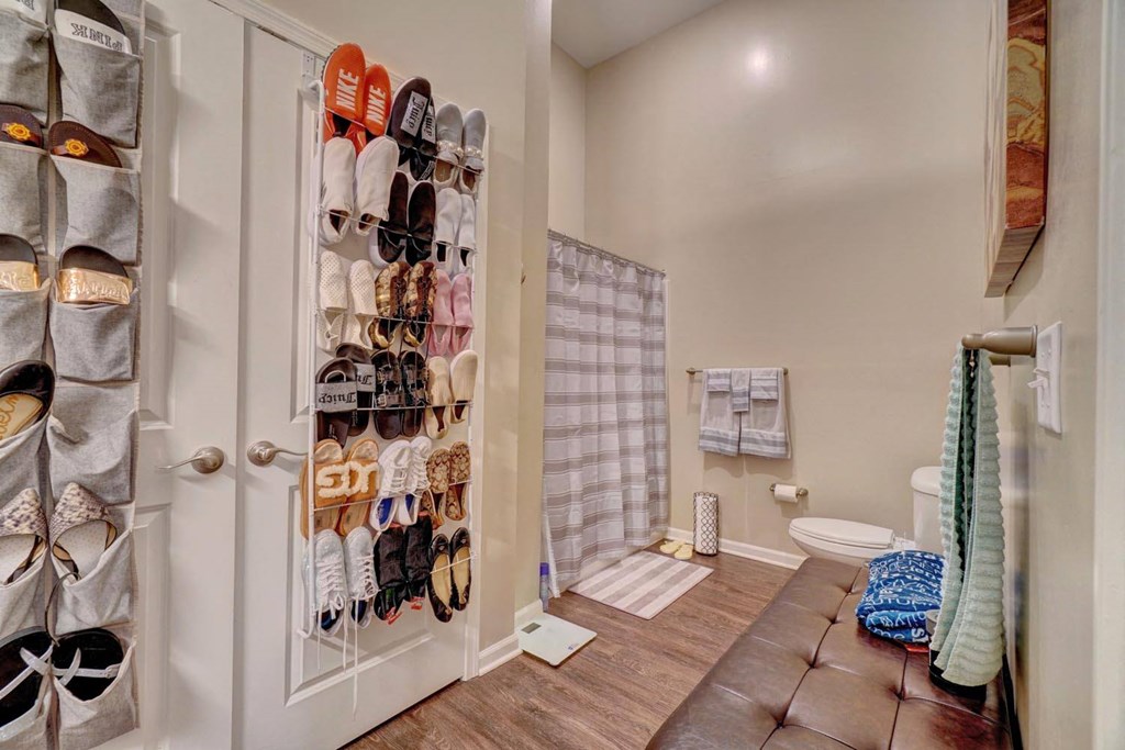 a closet filled with shoes next to a toilet