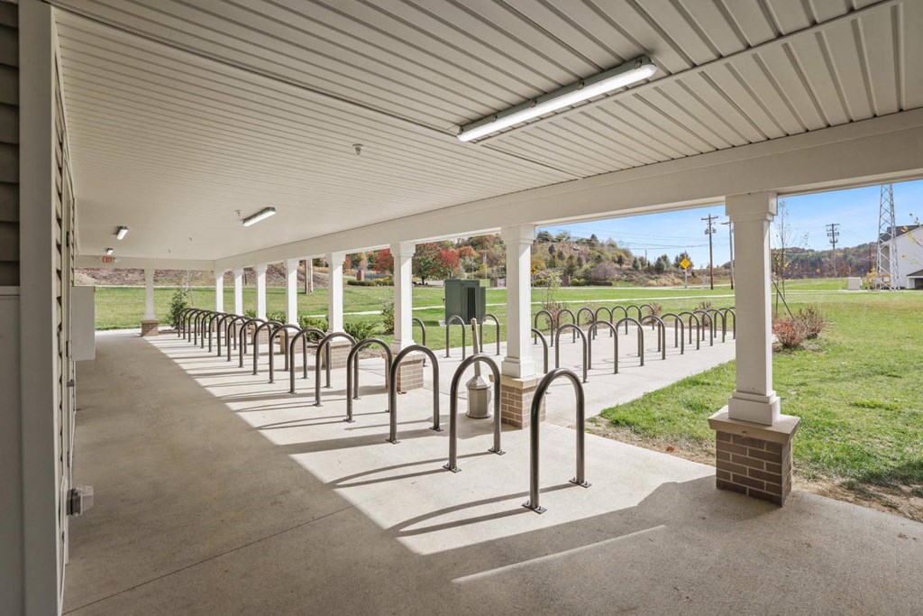a row of metal bike racks under a covered walkway