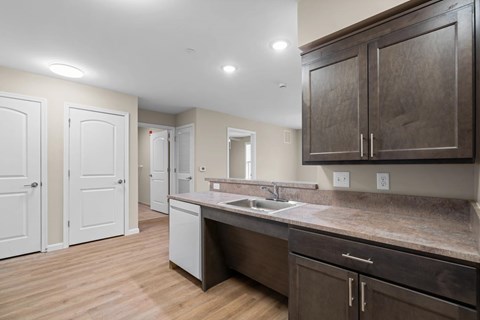 A kitchen with brown cabinets and a marble countertop.