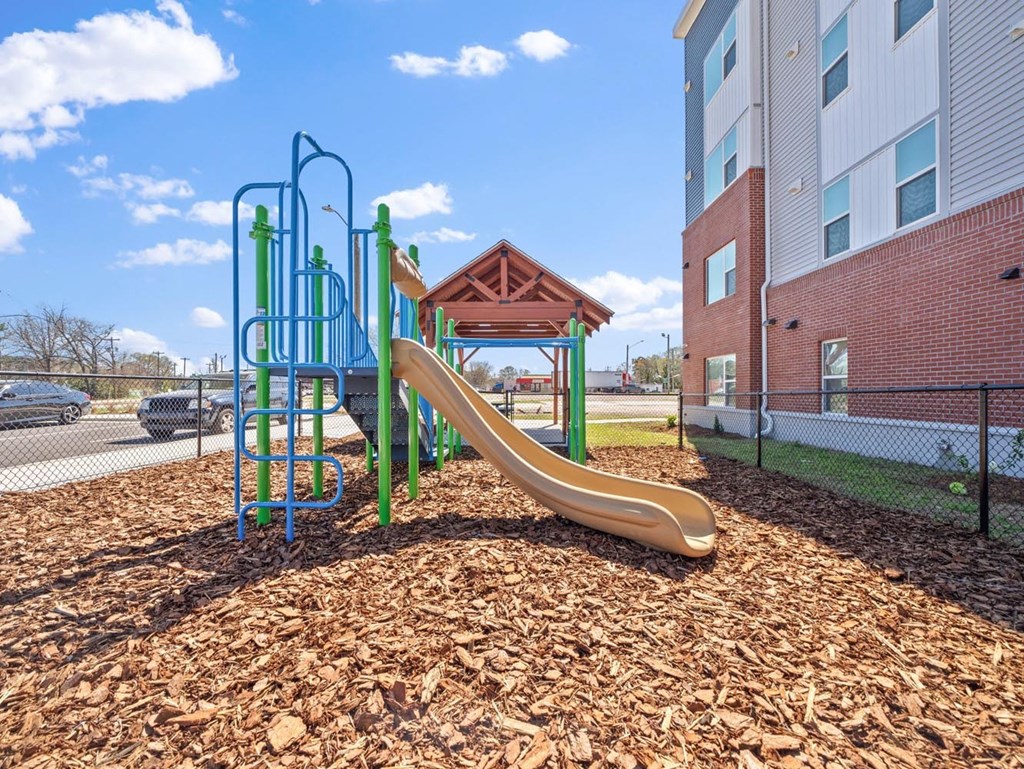 a playground with a slide at an apartment complex