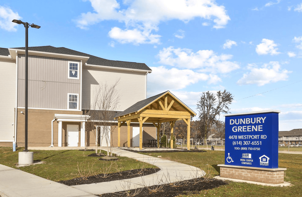 a building with a sign outside of dunedin greenery