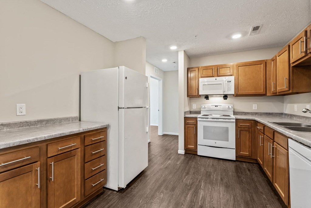 a kitchen with white appliances and wooden cabinets