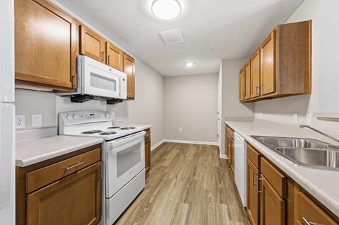 A kitchen with wooden cabinets and white appliances.