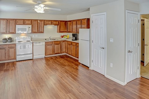 A kitchen with wooden cabinets and white appliances.