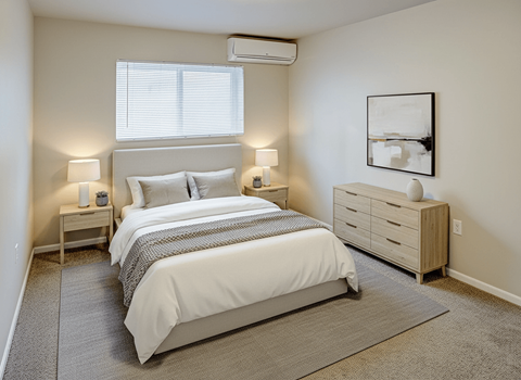 A bedroom with a large bed and a nightstand with a lamp.