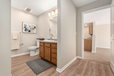 A bathroom with a toilet, sink, and mirror.