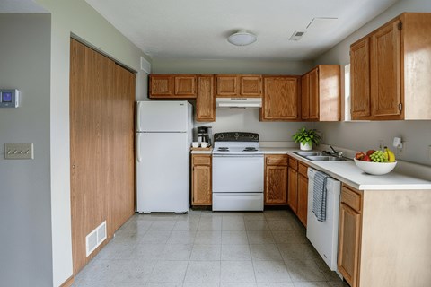 A kitchen with wooden cabinets and a white refrigerator.