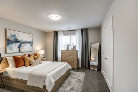 A bedroom with a large bed, a nightstand, and a painting on the wall.