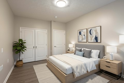 A bedroom with a bed, nightstand, and two framed pictures on the wall.
