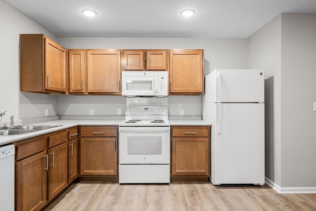 A kitchen with wooden cabinets and white appliances.