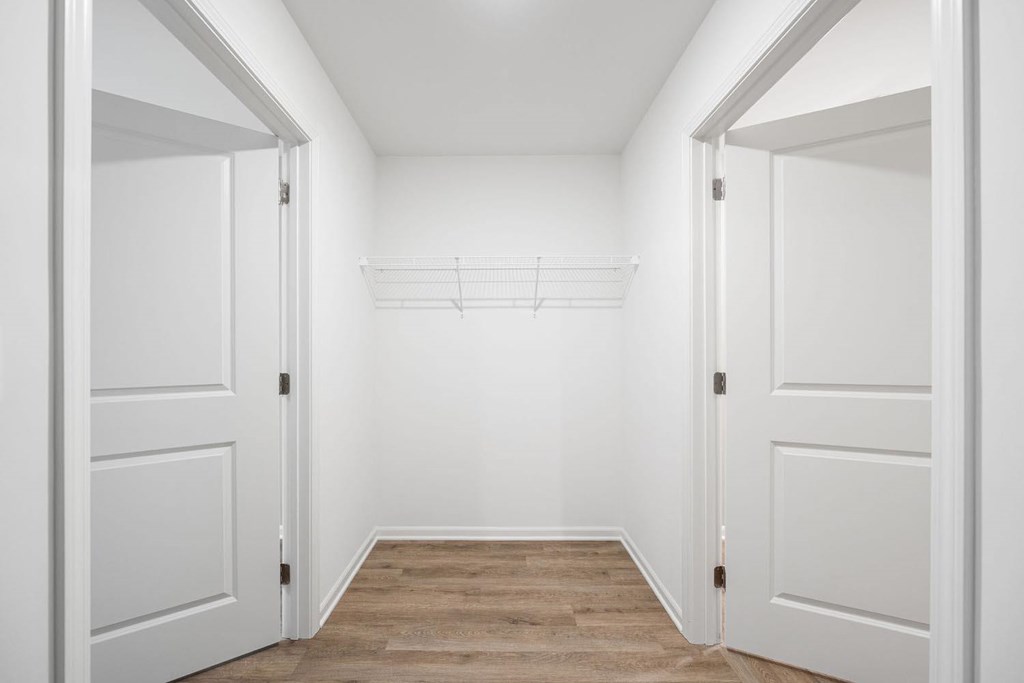 A hallway with white doors and a wooden floor.
