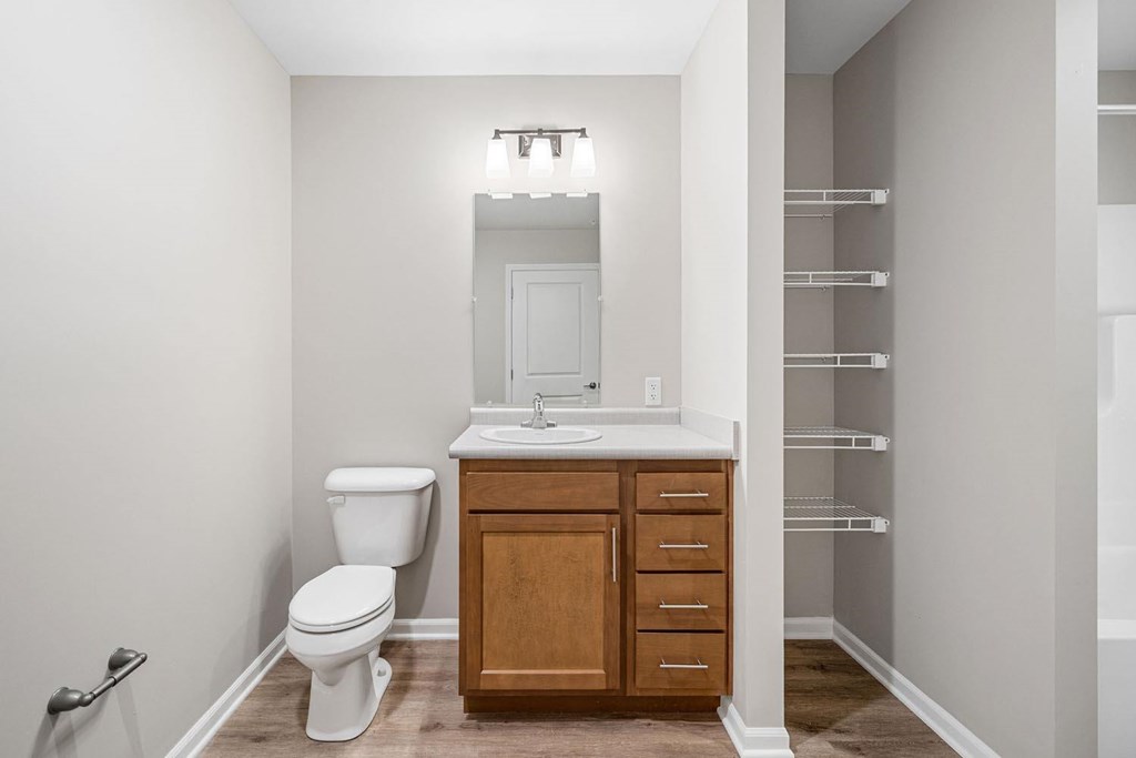 A bathroom with a toilet, sink, and medicine cabinet.