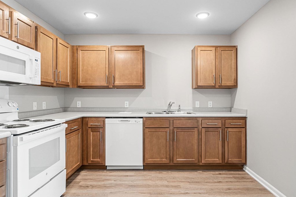 A kitchen with wooden cabinets and white appliances.