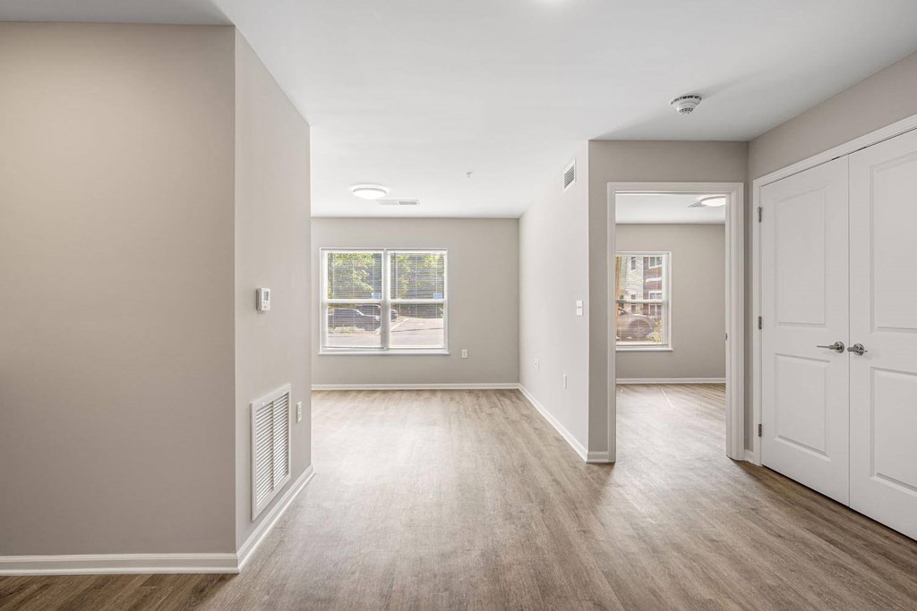 A room with a white door and a window with a view of a street.