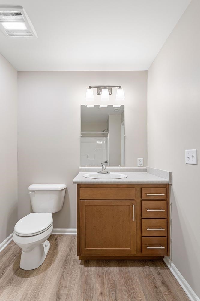A white toilet sits next to a sink in a bathroom.