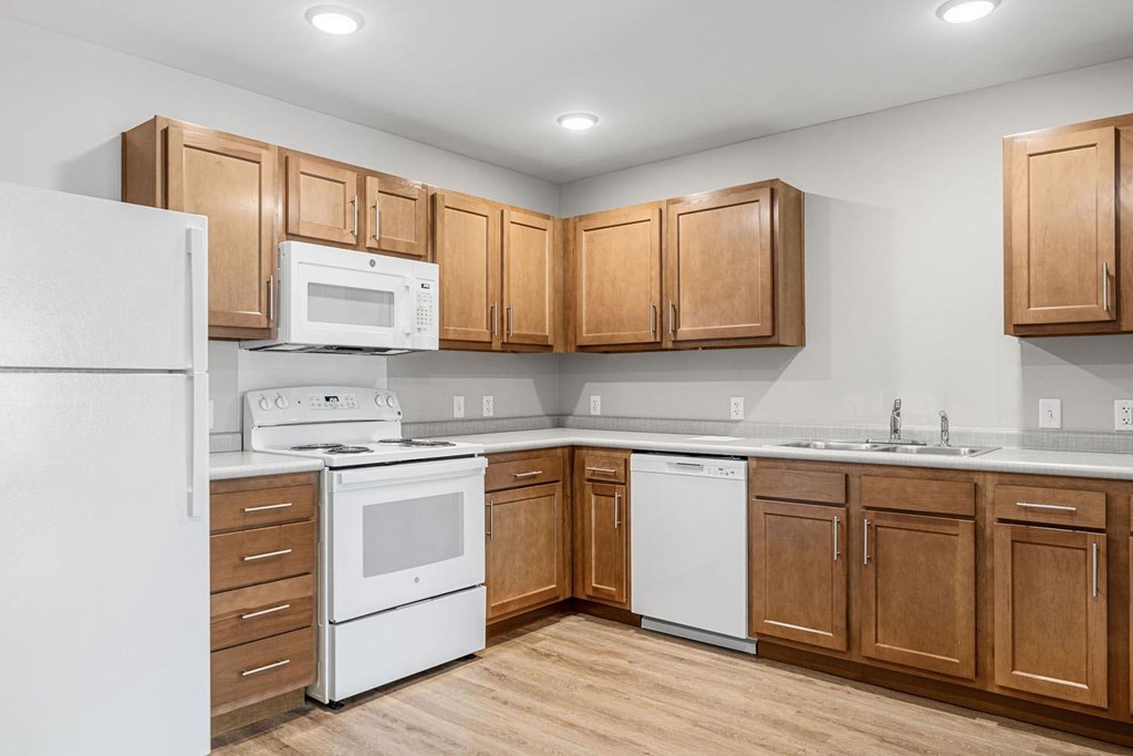 A kitchen with wooden cabinets and white appliances.