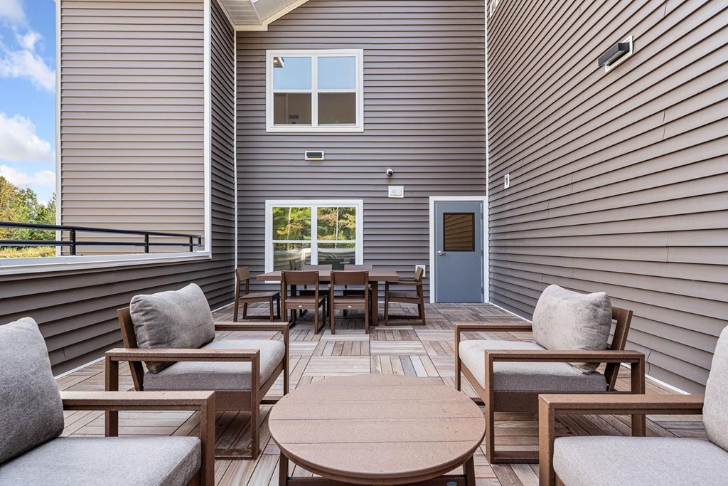 A wooden table and chairs are set up on a patio.