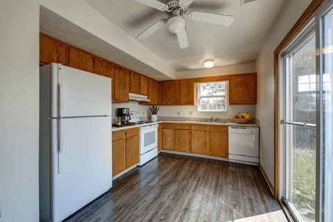 A kitchen with wooden cabinets and a white refrigerator.