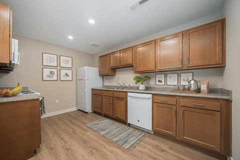 A kitchen with wooden cabinets and a white fridge.