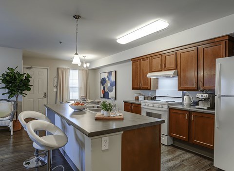 A modern kitchen with white appliances and wooden cabinets.