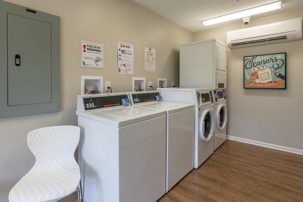 a laundry room with washing machines and a chair