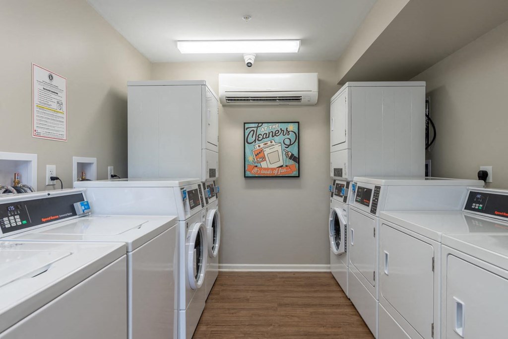 a laundry room with washers and dryers and a poster on the wall